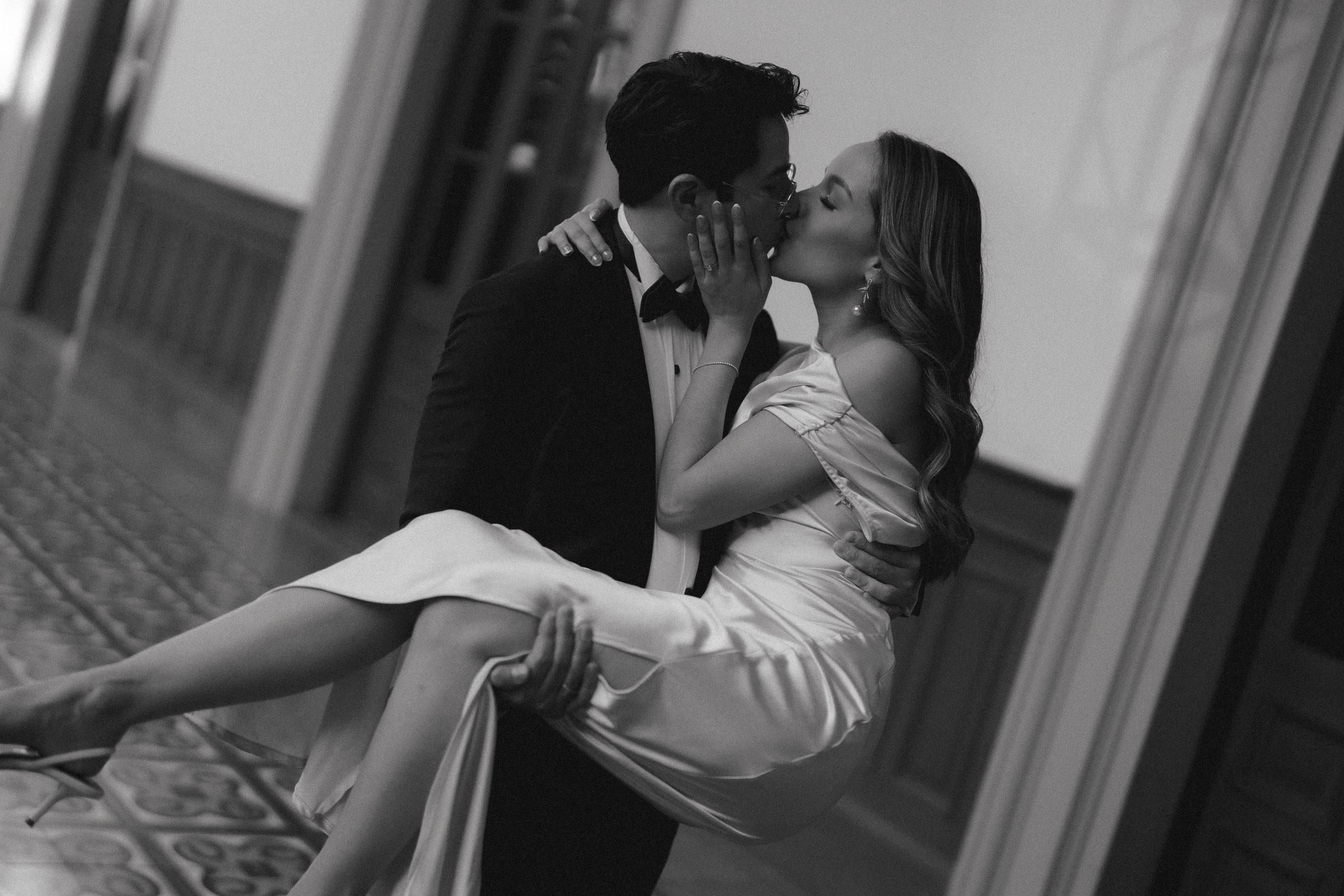 El novio carga a la novia en el corredor