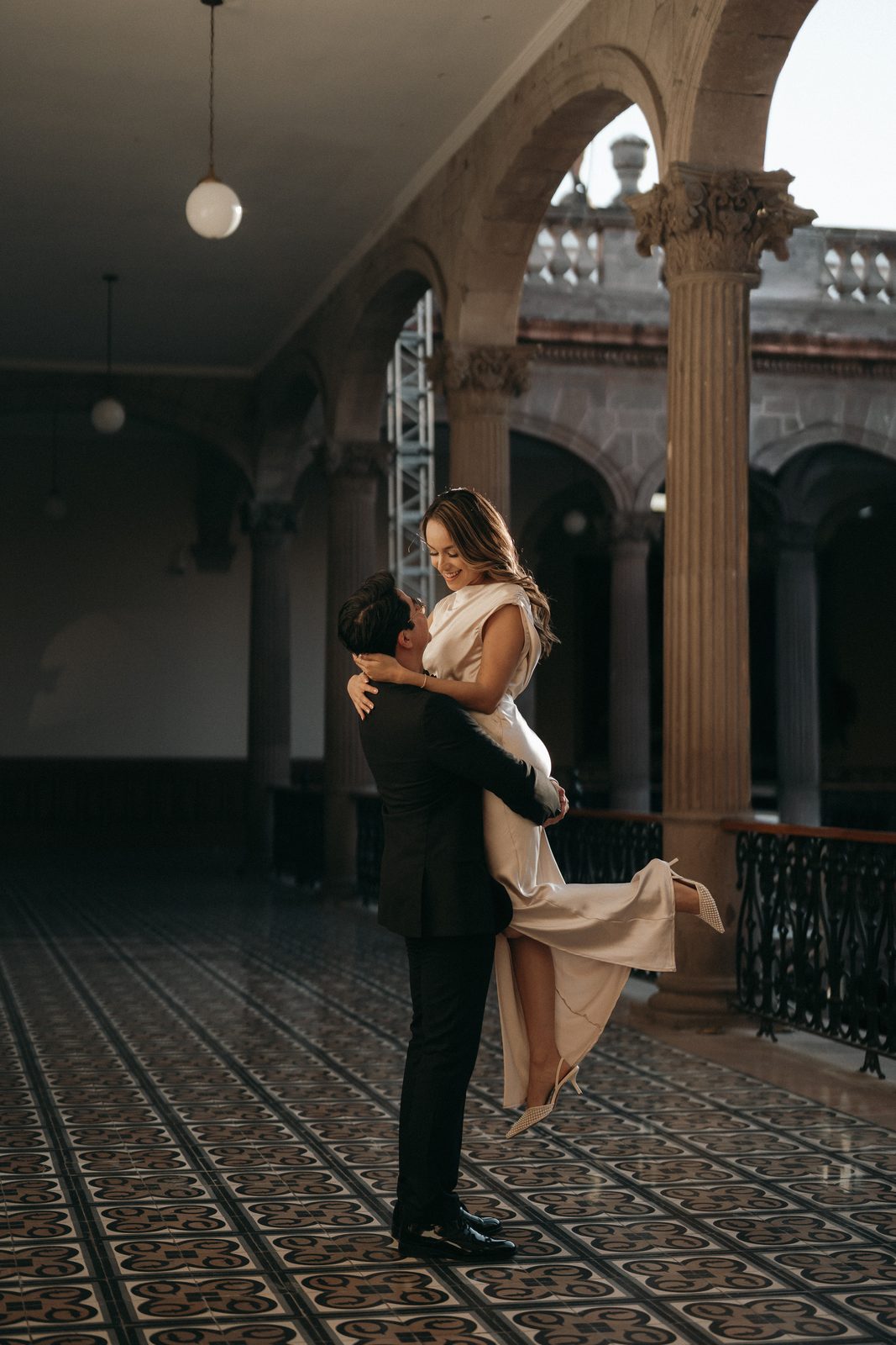 El novio levanta a la novia entre los arcos
